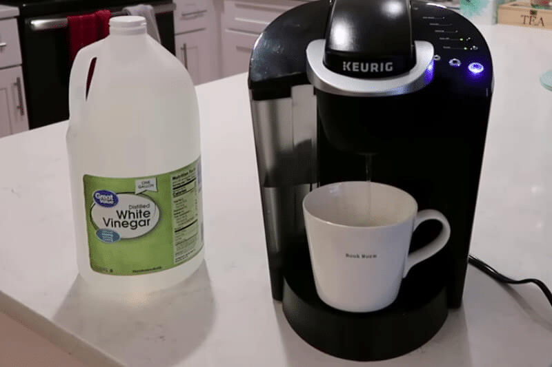 keurig placed with white vinegar bottle on table